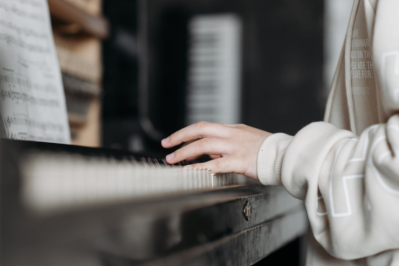 Mastering the First Impression: Your intriguing post title goes here Hands playing piano with sheet music in cozy indoor setting. Perfect for music education visuals.